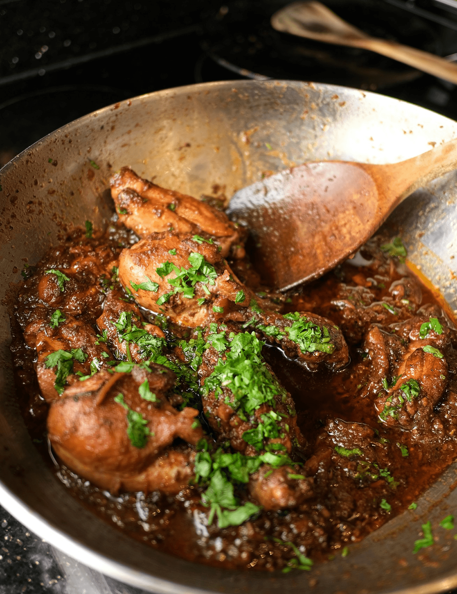 Chicken karahi cooking in a pan with fresh herbs
